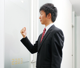 面接会場に入室しようとドアをノックしている就活生