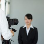 証明写真を撮影するスーツ姿の女性