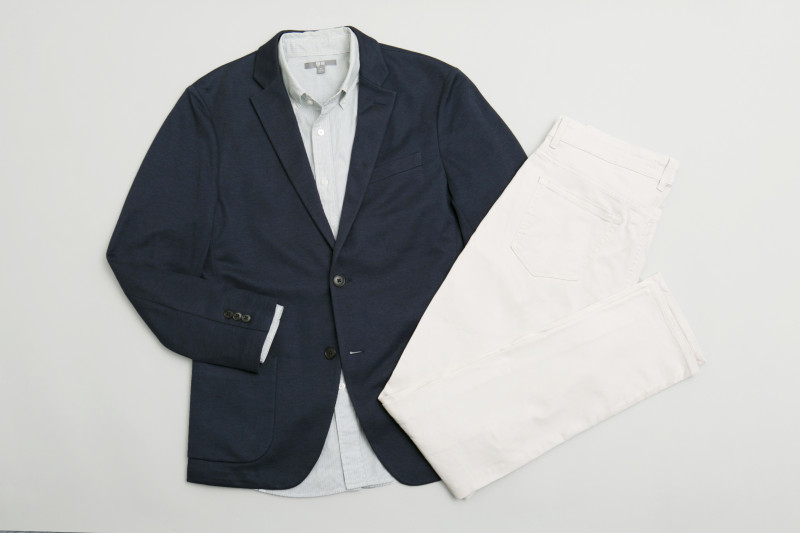 紺のジャケット、ストライプの入った薄いグリーンのワイシャツ、白のチノパンの写真