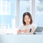 テキストを開いて勉強する女性