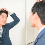 鏡の前で髪を整える様子