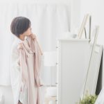 鏡の前で洋服を選ぶ学生